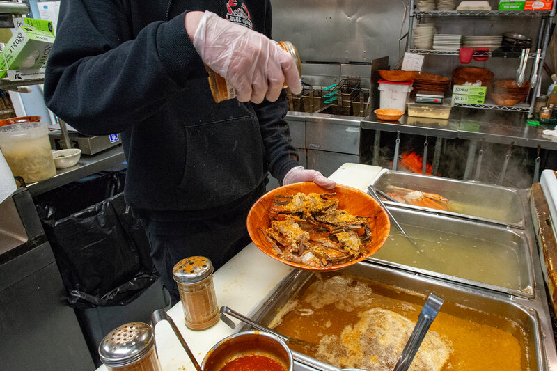 Cook sprinkling crab legs with seasoning